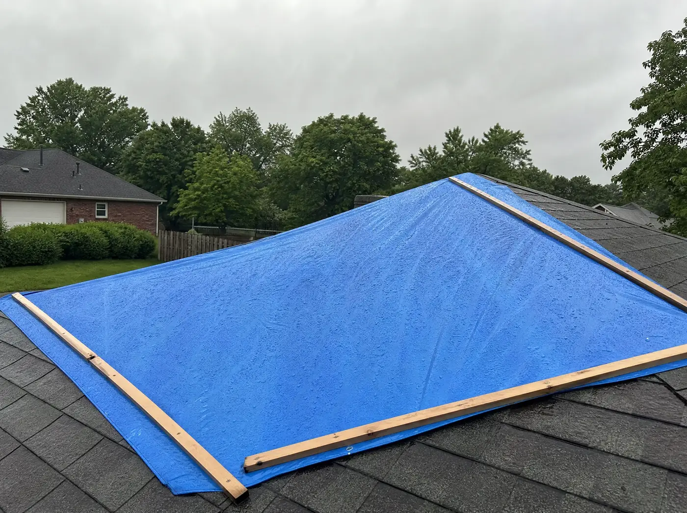 Emergency roof tarp battened down over storm damage on a Springfield MO house