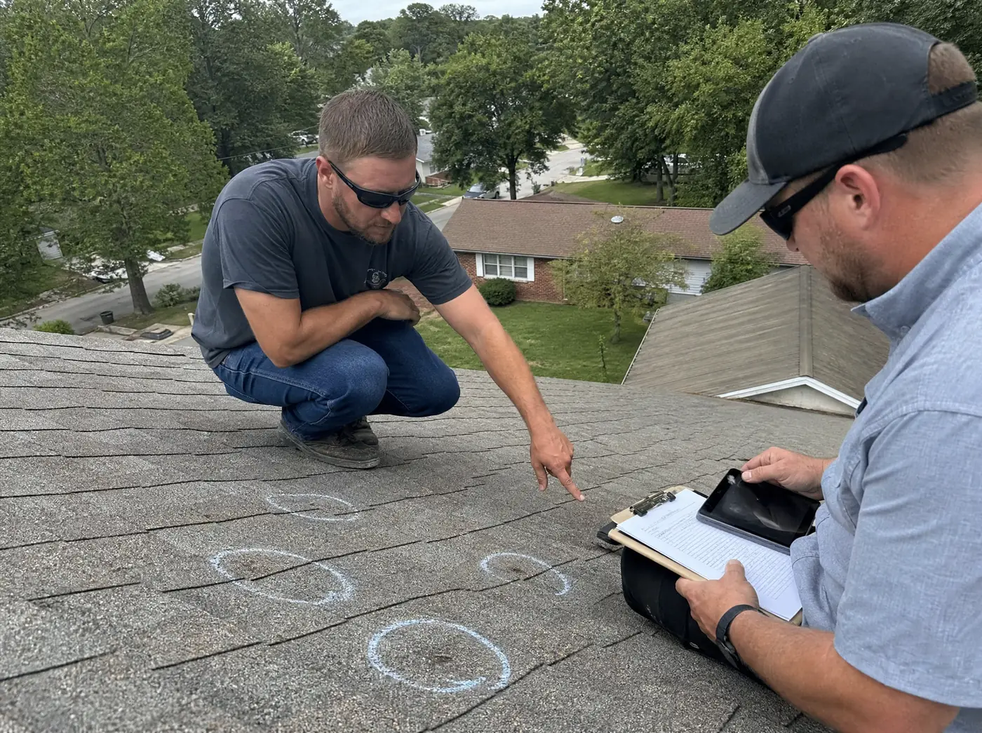 Roofer and insurance adjuster documenting hail damage on a Springfield MO roof
