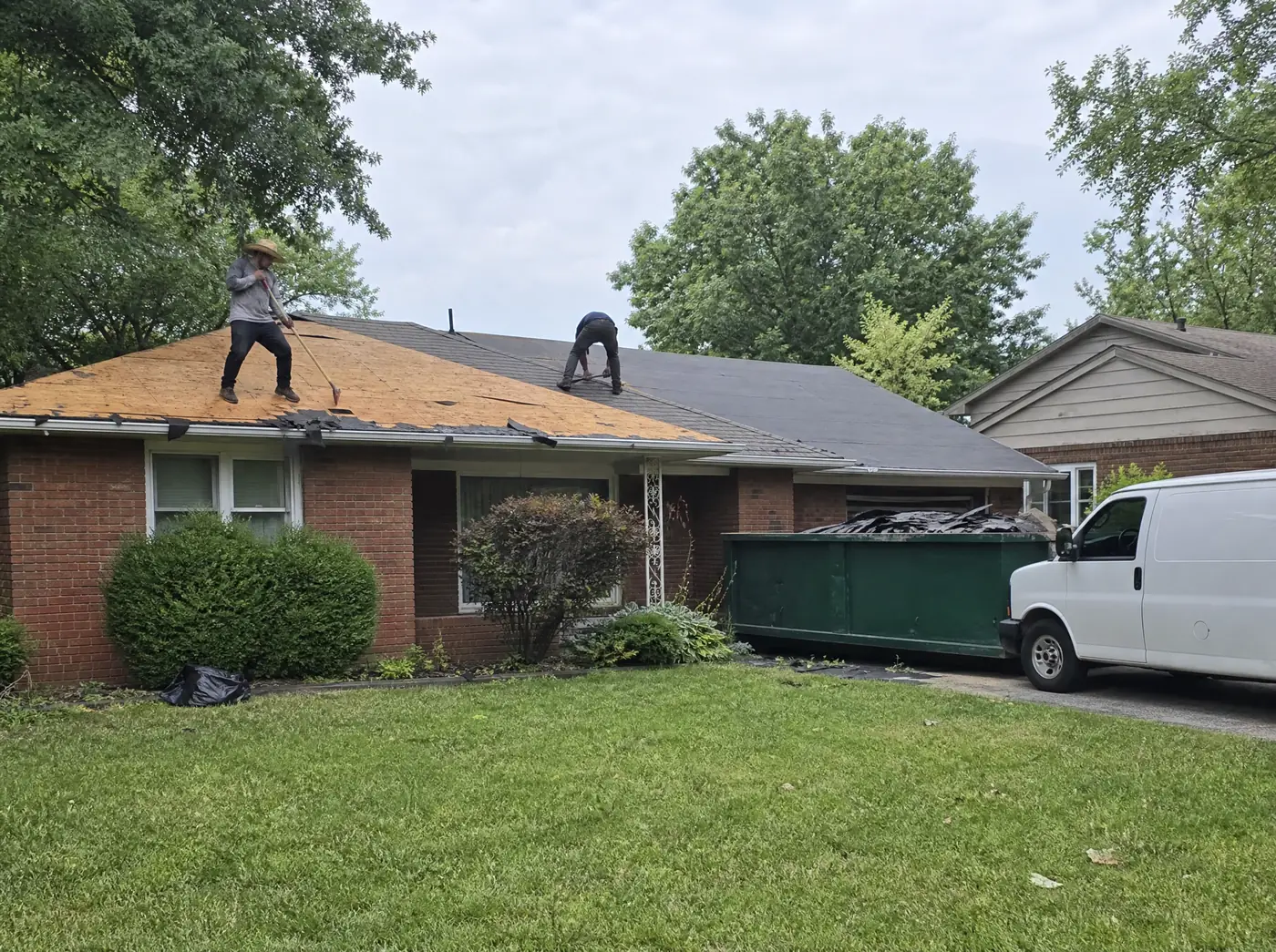 Roofing contractors in Springfield MO tearing off hail damaged shingles