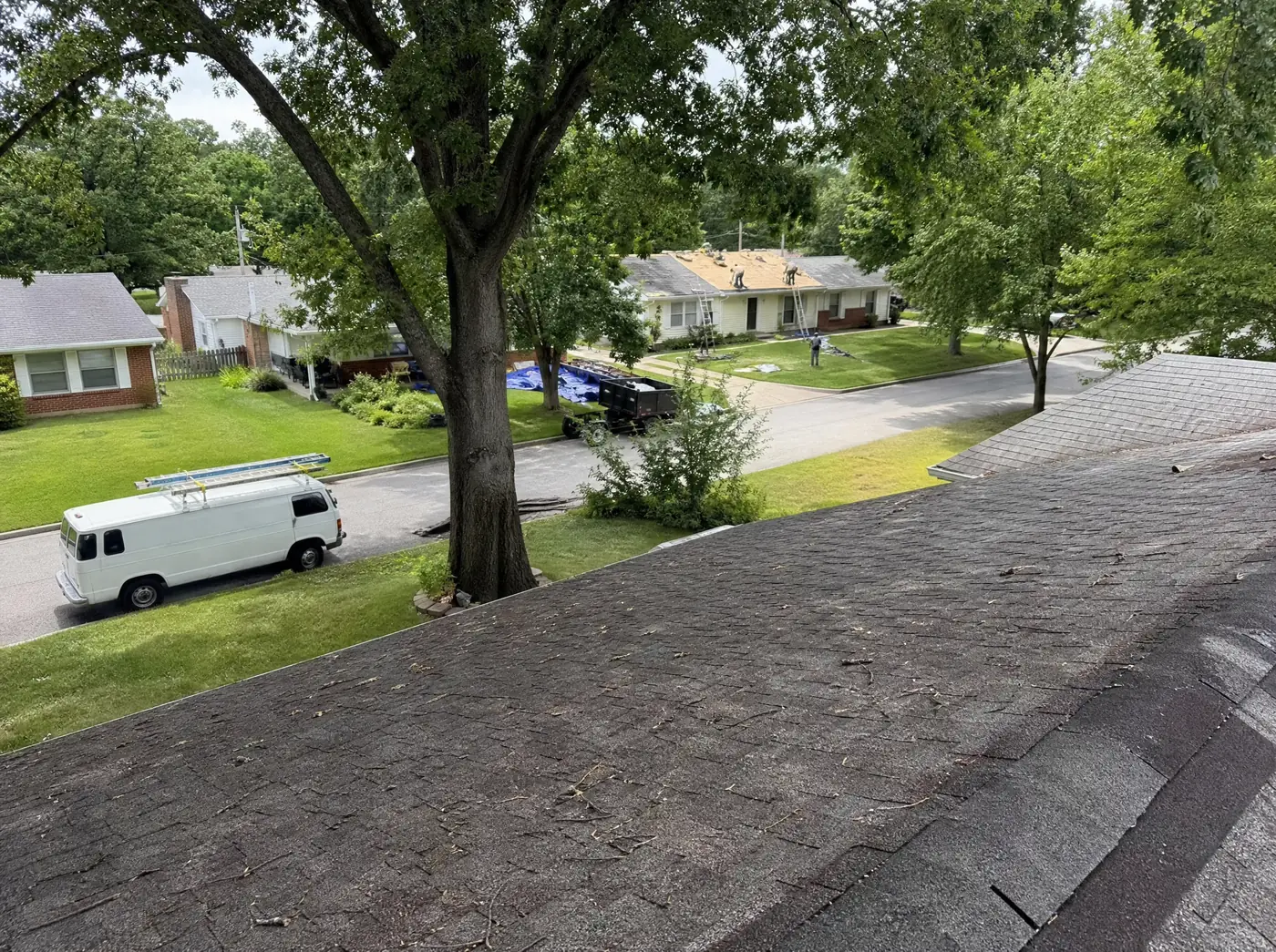 Roofing crew working across a Springfield MO neighbourhood rooftop